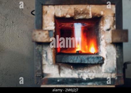 Forgeron four avec flamme chaude. Smith chauffage de fer morceau d'acier dans le feu de forge rouge-chaud Banque D'Images