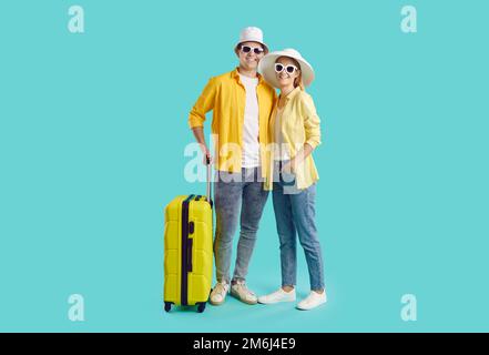 Joyeux jeune couple dans des vêtements d'été décontractés pour les vacances d'été avec une valise Banque D'Images