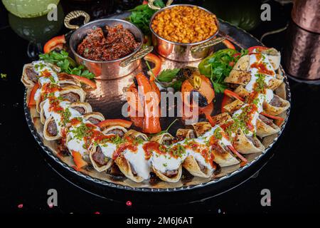 Cuisine turque traditionnelle Sarma Beyti Kebab. Cuisine traditionnelle turque et arabe du Ramadan Kebap Beyti Sarma avec yaourt, servant du pain de lave à l'intérieur Banque D'Images