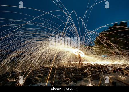 Jouer avec des flammes tenant un feu à cause flakes Banque D'Images