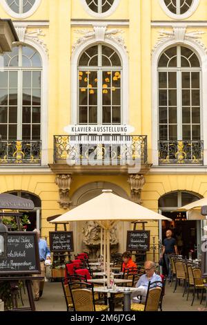 Photo extérieure du salon de piano Dresdner, restaurant et café dans le centre de Dresde, où les convives se détendent à des tables en plein air sous des canapés crème Banque D'Images