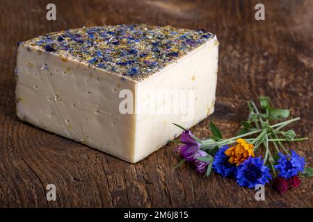 Fromage de montagne avec fleurs sur bois Banque D'Images