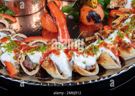 Cuisine turque traditionnelle Sarma Beyti Kebab. Cuisine traditionnelle turque et arabe du Ramadan Kebap Beyti Sarma avec yaourt, servant du pain de lave à l'intérieur Banque D'Images