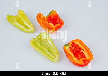 Poivrons verts et rouges coupés en deux isolés sur fond blanc. Contour de coupe. Vue de dessus Banque D'Images