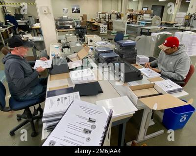 Michael Tuliback et Samuel Liriano, les opérateurs d'équipement électronique de DLA document Services Philadelphie, connaissent la signification de la patience car ils attachent des spirales à 2000 manuels pour un client. 28 avril 2022. Photo de Nutan Chada, DLA public Affairs. Banque D'Images