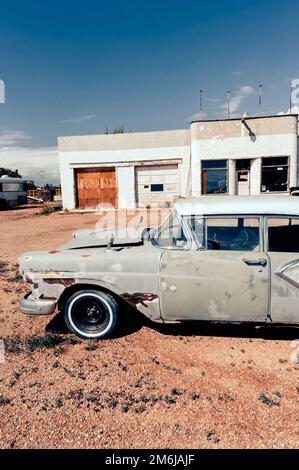 Vieille berline 500,4 portes Ford Fairlane 1959 rouillée, stationnée devant une station-service abandonnée Banque D'Images