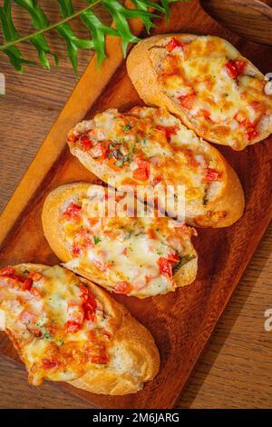 Gros plan sur l'apéritif italien bruschettas avec sauce tomate et parmesan sur la table en bois, à l'horizontale. Banque D'Images