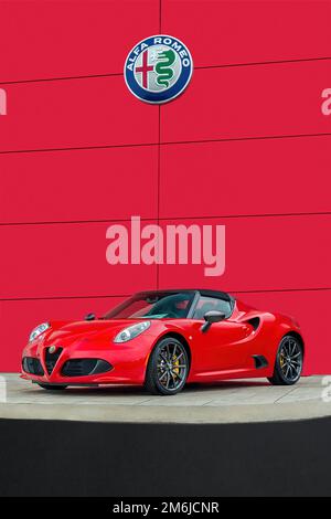 Maryville, Tennessee, États-Unis - 16 mai 2016: Une voiture de sport Alfa Romeo 4CII reposant sous le légendaire logo Alfa avec fond rouge et beaucoup o Banque D'Images