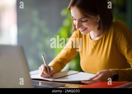 Gros plan de jolie dame assistant à la formation en ligne, intérieur de café Banque D'Images