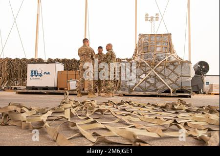 ÉTATS-UNIS Force aérienne Brig. Le général Robert Davis, à gauche, commandant de la 378th Air Expeditionary Wing, apprend à traiter les cargaisons entrantes provenant du Sgt. Oscar Lopez et du Sgt. Enrique Flores, tous deux représentants de l'exploitation des passagers au Centre des opérations de l'aérogare, Au cours d’une visite « Roll Up Sleeves » avec des aviateurs de l’escadron 378th de préparation logistique expéditionnaire, à la base aérienne du Prince Sultan, Royaume d’Arabie saoudite, à 28 avril 2022. Davis et le Sgt. Principal Jackson Helzer, chef de commandement de l'AEW 378th, visitent régulièrement des aviateurs sous leur commandement, pour faire l'expérience de leur travail et Banque D'Images