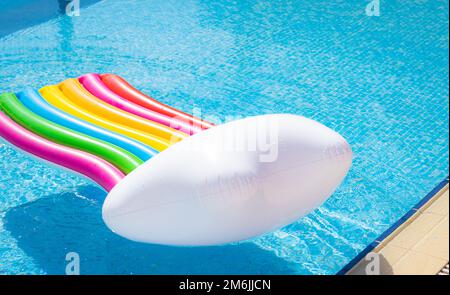 Matelas gonflable, couleurs arc-en-ciel. nager dans la piscine par beau temps. Banque D'Images