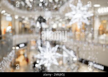 Les étoiles et les guirlandes de Noël sont floues sous forme de bokeh à l'intérieur de la salle de fête. Image avec effet de flou Banque D'Images