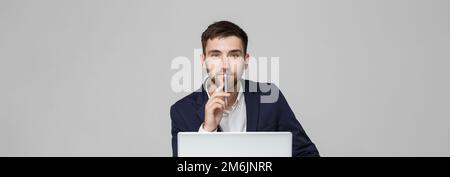 Concept d'affaires - Portrait beau heureux beau homme d'affaires en costume jouer à la moblie téléphone et sourire avec ordinateur portable au travail de Banque D'Images