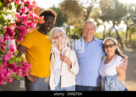 Portrait de heureux multiracial amical adulte mature personnes debout à l'extérieur liant et posant Banque D'Images
