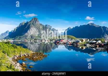 Reflet parfait du village de Reine sur l'eau du fjord dans les îles Lofoten, en Norvège Banque D'Images