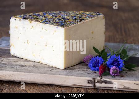 Fromage de montagne avec fleurs sur bois Banque D'Images