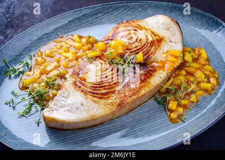 Steak d'espadon frit avec chutney de mangue et herbes servi en gros plan sur une assiette de style nordique Banque D'Images