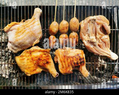 Gai yang également connu sous le nom de kai ping ou gai ping est un poulet grillé de style thaï sur un rack en fil de fer. Street Food Thailand concept. Banque D'Images