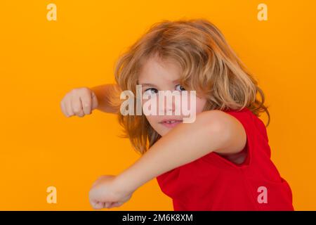 Enfant en colère avec le combat gestuel poing, frapper sur un arrière-plan isolé de studio. Enfant avec punch main d'expression folle. Mauvais comportement des enfants. Fureur. Banque D'Images