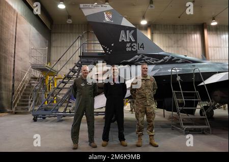 ÉTATS-UNIS Le colonel de la Force aérienne Thomas Wolfe, vice-commandant de l'escadre du 354th Fighter (au centre), pose avec le colonel Gage Evert, commandant du Groupe des opérations 354th (à gauche), Et le colonel Matthew Powell, commandant du groupe de maintenance 354th (à droite), à la suite d’une cérémonie de dévoilement du flash de queue nouvellement peint sur le faucon de combat F-16 de l’aile, sur la base aérienne d’Eielson, en Alaska, au 29 avril 2022. Le flash de queue présente des images qui rendent hommage à l'histoire de la base et à son emplacement dans l'intérieur de l'Alaska, avec des montagnes, un emblème d'aile historique et diverses silhouettes de jet. Banque D'Images