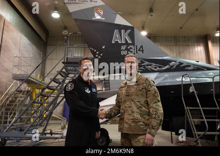 ÉTATS-UNIS Le colonel de la Force aérienne Thomas Wolfe, vice-commandant de l’escadre de combat 354th (à gauche), pose avec le colonel Matthew Powell, commandant du groupe de maintenance 354th (à droite), à la suite d’une cérémonie de dévoilement du flash de queue nouvellement peint sur le faucon de combat F-16 de l’aile, sur la base aérienne d’Eielson, en Alaska, au 29 avril 2022. Le flash de queue présente des images qui rendent hommage à l'histoire de la base et à son emplacement dans l'intérieur de l'Alaska, avec des montagnes, un emblème d'aile historique et diverses silhouettes de jet. Banque D'Images