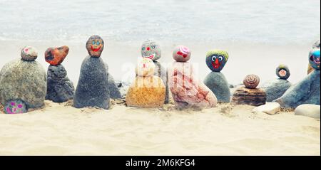 Pierres équilibré sur une plage de galets au coucher du soleil. Banque D'Images