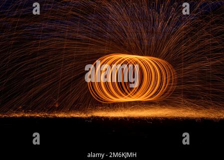 Cercle orange lumière en mouvement feux sur fond noir. Banque D'Images