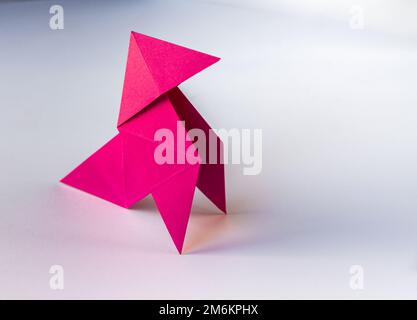Origami de poule de papier rose isolé sur fond blanc Banque D'Images