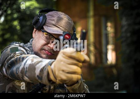 Jeune homme au cours de formation tactique de la police civile. Homme avec un fusil dans un casque militaire de protection auditive tactique uniforme. Polic Banque D'Images