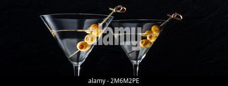 Martini, deux verres aux olives épicées, sur fond noir Banque D'Images