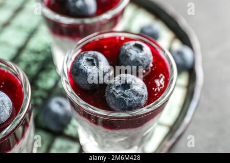 Assiette avec des doses de délicieux pudding de graines de chia et de myrtille sur table noire, gros plan Banque D'Images