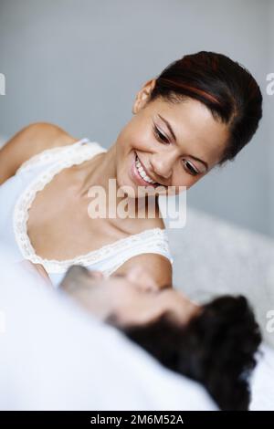 Bonjour. Jolie femme couchée au lit à côté de son petit ami. Banque D'Images