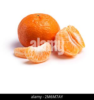 Savourez le goût. Studio de tranches de mandarine à côté d'un fruit entier. Banque D'Images