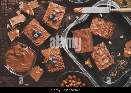 Composition de carrés de brownie au chocolat frais faits maison qui fondent le chocolat et les bleuets frais Banque D'Images