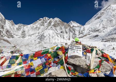 CAMP DE BASE DE L'EVEREST TREK/NÉPAL - 01 NOVEMBRE 2015 : panneau du camp de base de l'Everest avec pierres et drapeaux de prière bouddhistes et Everest de montagne en arrière-plan. Banque D'Images