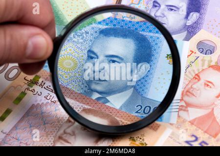 Dirham marocain dans une loupe un arrière-plan d'affaires Banque D'Images