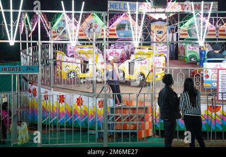 28 novembre, Raipur, inde, parc d'attractions indien de fête du carnaval de nuit homme debout à cheval et les gens regardant autour Banque D'Images