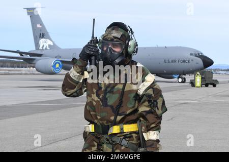 Tech. Le Sgt Blayne Kiser du groupe de maintenance 168th transmet des informations opérationnelles par radio, assurant ainsi la préparation au ravitaillement en vol tout en s'formant dans un environnement contesté simulé. Les aviateurs du Groupe de maintenance de la 168th e Escadre effectuent des opérations de maintenance dans un environnement dégradé simulé en portant un équipement de posture de protection orienté mission lors d'un exercice de préparation à la base aérienne d'Eielson. Les aviateurs de la Garde nationale aérienne de l'Alaska se préparent régulièrement à des éventualités, prêts à répondre aux besoins de l'État et de la nation. La 168th Wing assure une livraison rapide de en vol Banque D'Images