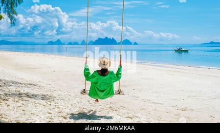 Femme sur la plage dans une balançoire de l'île tropicale de l'île de Naka près de Phuket Thaïlande Banque D'Images