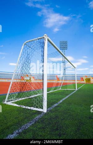 STADE - terrain de football avec but et tapo sur ciel bleu Banque D'Images