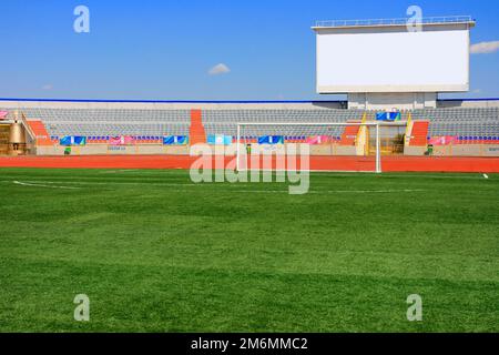 STADE - terrain de football avec but et tapo sur ciel bleu Banque D'Images