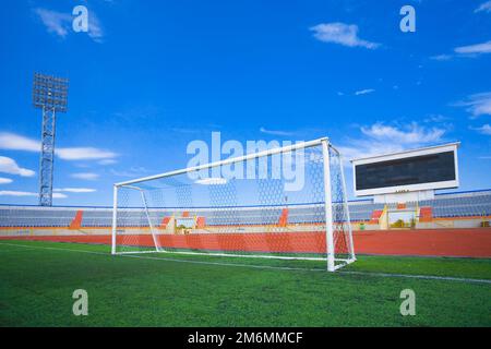 STADE - terrain de football avec but et tapo sur ciel bleu Banque D'Images