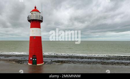 Phare rouge et blanc au bord de la mer à westkapelle, walcheren, pays-bas, à Winte Banque D'Images