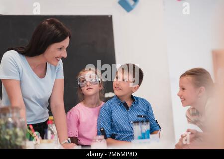 École élémentaire de sciences en classe: Un professeur enthousiaste explique la chimie à divers groupes d'enfants, Little Boy Mixes Chem Banque D'Images