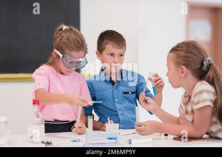 École élémentaire de sciences en classe: Un professeur enthousiaste explique la chimie à divers groupes d'enfants, Little Boy Mixes Chem Banque D'Images