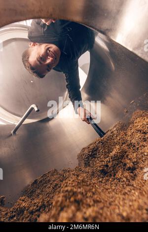 L'écrasement de graines de malt broyé pour la préparation du malt. Processus de grain d'orge de brasserie. Banque D'Images