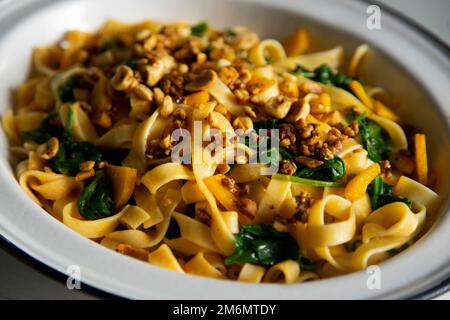 Tagliatelle aux épinards et à la citrouille. Pâtes italiennes fraîches avec légumes. Banque D'Images