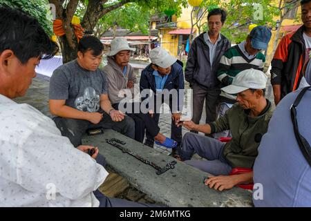 Hoi an, Vietnam - 29 décembre 2022: Un groupe d'hommes jouant des dominos dans une rue à Hoi an., Vietnam. Banque D'Images