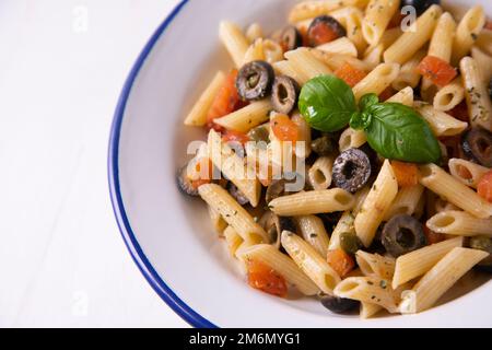 Pâtes alla siciliana. Pâtes avec sauce tomate, basilic et olives noires. Banque D'Images