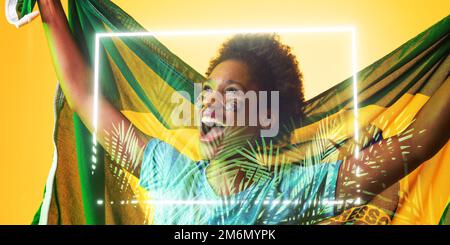 Fan afro-américain avec drapeau brésilien et peinture de visage criant par rectangle et plantes Banque D'Images